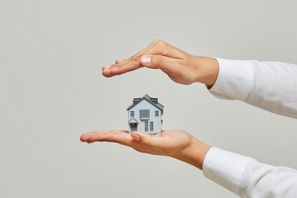 Hands protecting home for Bastrop TX property maintenance